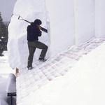 Winterkeepers must remove snow all winter to keep roofs from caving in. Jeff Henry, a winterkeeper in Yellowstone and a professional photographer, is shown on the Hamilton Store dorm at Old Faithful in 1997 when the snow on the ground was 22-feet deep.   ©Jeff Henry/Roche Jaune Pictures, Inc.